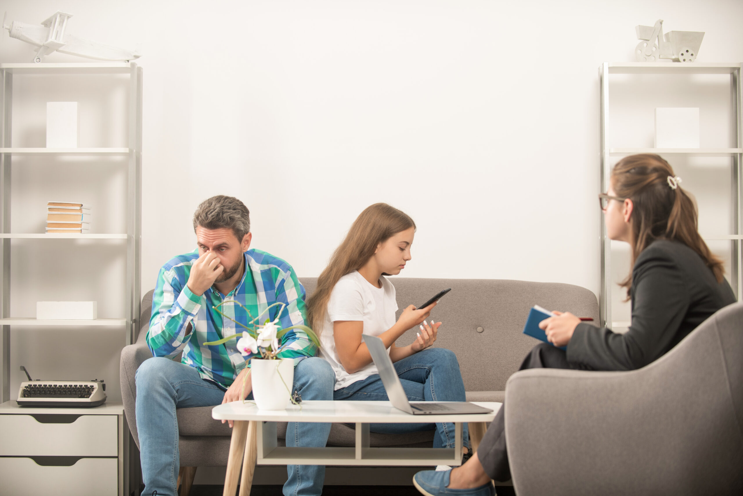 family therapy. parent-teacher meeting. parenthood and fatherhood. kid and dad talk to social worker. interpersonal relations. life coach. phone addiction. father and daughter at psychologist session.